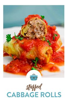 stuffed cabbage rolls on a white plate with red sauce and parsley garnish