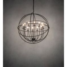 a chandelier with many lights hanging from it's center and circular metal frame