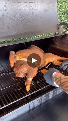 a chicken is being cooked on an outdoor bbq grill with the lid open to show it's skin