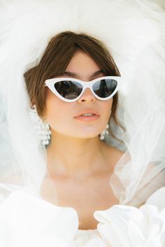 a woman wearing white sunglasses and a veil