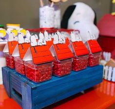 there are many plastic containers with candy in them on the table and one is red