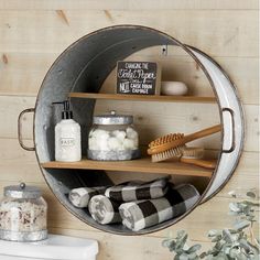 a metal bucket filled with lots of items on top of a wooden shelf next to a sink