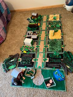 a table topped with lots of cake covered in green frosting next to a wall