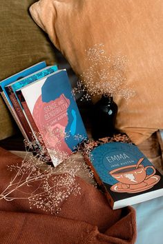 two books sitting on top of a bed next to pillows