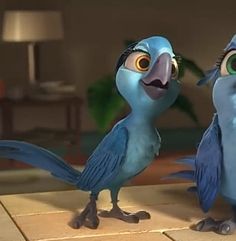 two blue birds standing next to each other on a tile floor in front of a lamp