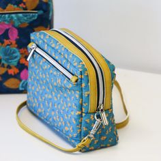 two small purses sitting next to each other on top of a white countertop