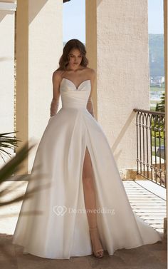 a woman in a white wedding dress posing for the camera