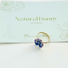 Update your look with a touch of color using our enchanting Enamel Purple Pansy Adjustable Ring. These lovely pansy flowers will elevate your look and add a touch of femininity. This ring's open adjustable design lets you wear it on various fingers for versatile styling options, so your hands can dazzle in a multitude of ways. The pansy's symbolism extends beyond love potions and secret messages. It's a complex icon of love—romantic, platonic, and affectionate. Enhance your appearance and expres Love Potions, Pansy Flowers, Purple Pansy, Love Romantic, Secret Messages, Adjustable Ring, Pansies, Adjustable Rings, Violet