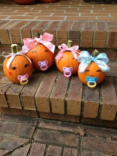 three pumpkins with faces and bows on them