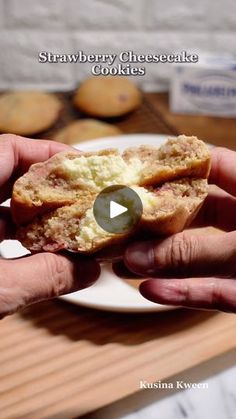 a person holding a piece of bread with an egg in it on a white plate