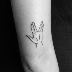 a black and white photo of a person's arm with a tattoo on it