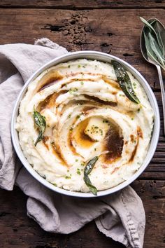 a bowl filled with mashed potatoes on top of a wooden table