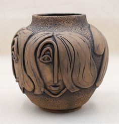 a ceramic vase with a woman's face on it