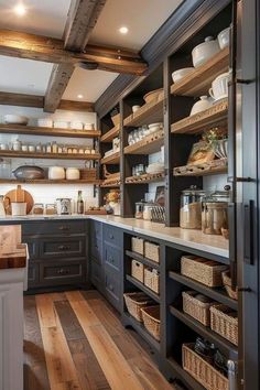 an open kitchen with lots of shelves and baskets on the counter top, along with wooden flooring