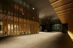 an empty room with wooden slats on the walls and lights shining down from the ceiling