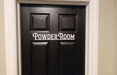 a black door with the word powder room painted on it