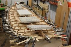 many different tools are lined up on a table in a room filled with woodworking supplies