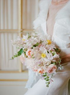 a bride holding a bouquet of flowers in her hands