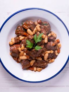 a white bowl filled with meat and beans