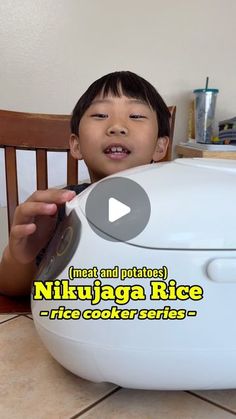 a young boy sitting in front of a white rice cooker