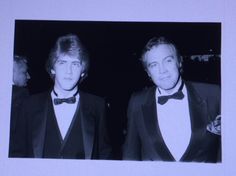 two men in tuxedos are standing next to each other