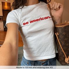 "So American 4th Of July USA" Graphic Slogan Printed On Aesthetic Retro Vintage 90s Y2k Baby Tee Shirt with our own unique font.  🎨 Available in White, Light Pink, Light Blue, Navy, Black. If you need a different color, please let us know! (Ash, Red, Sport Grey & Green)  🎁 Our baby tees are perfect gift for her or him offering timeless fashion and versatility that anyone will cherish. Baby tees, popular in the '90s, have short sleeves and a slightly cropped body, giving a flattering feminine s White Y2k Pre-shrunk Tops, Y2k Relaxed Fit Shirt With Letter Print, Y2k Streetwear Pre-shrunk Tops, Retro Tops With Letter Print For Everyday, Unisex Summer Top With Logo Print, Y2k Pre-shrunk Relaxed Fit Tops, 90s Style Cotton Tops With Letter Print, 90s Style Cotton Tops For Everyday, Unisex Y2k White Top