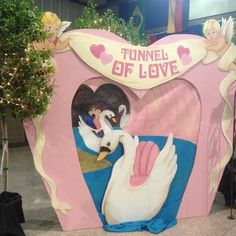 there is a fake swan in the shape of a tunnel of love with two swans inside