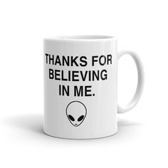 a white coffee mug with an alien saying thanks for believing in me on the front