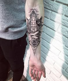 a man with a lighthouse tattoo on his arm