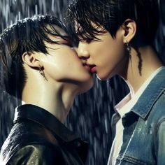 two people are kissing in the rain with their heads close to each other's faces