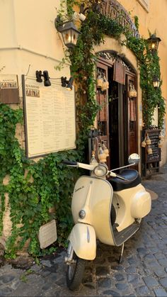 a scooter parked in front of a building with ivy growing up the side