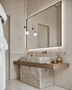 a bathroom with marble counter top and mirror above the sink in front of a robe rack