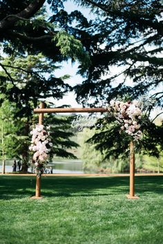 an outdoor ceremony setup with flowers and greenery on the grass, in front of trees