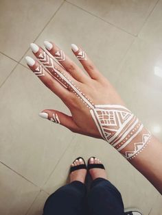 a woman's hand with white and black designs on it