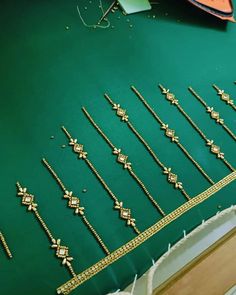 a green table topped with lots of gold jewelry