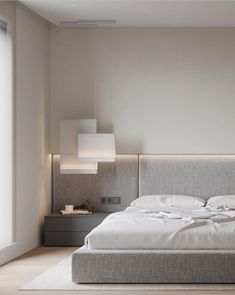 a large bed sitting in the middle of a bedroom next to a wall mounted light