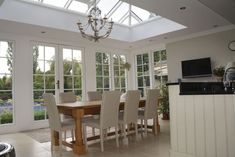 a dining room table surrounded by chairs and windows