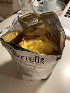 a bag of tortilla chips sitting on top of a table next to a laptop