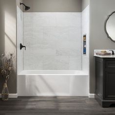 a bathroom with a tub, sink and mirror on the wall next to the toilet