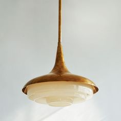 a light fixture hanging from a ceiling in a room with white walls and flooring