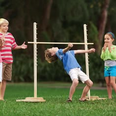 an older man and two young children playing with a wooden cross