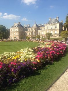 a large building with lots of flowers in front of it