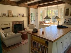 a living room with a couch, chair and fire place in the middle of it