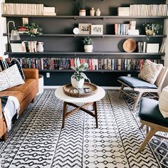 a living room filled with furniture and bookshelves next to a wall full of books