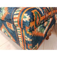 an upholstered footstool with multicolored designs on the top and bottom