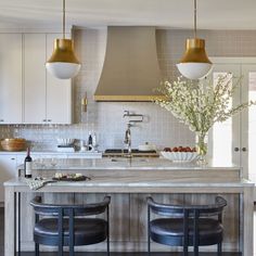 a kitchen with two bar stools next to an island