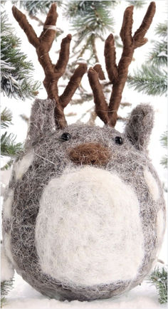 a close up of a stuffed animal in the snow with antlers on it's head