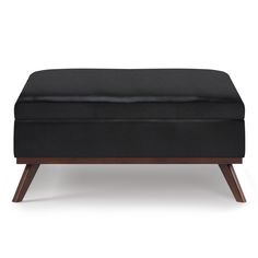 a black ottoman sitting on top of a wooden frame