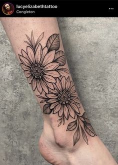 a black and white flower tattoo on the foot