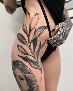 a woman with tattoos on her stomach and some sort of flower in the middle of her thigh